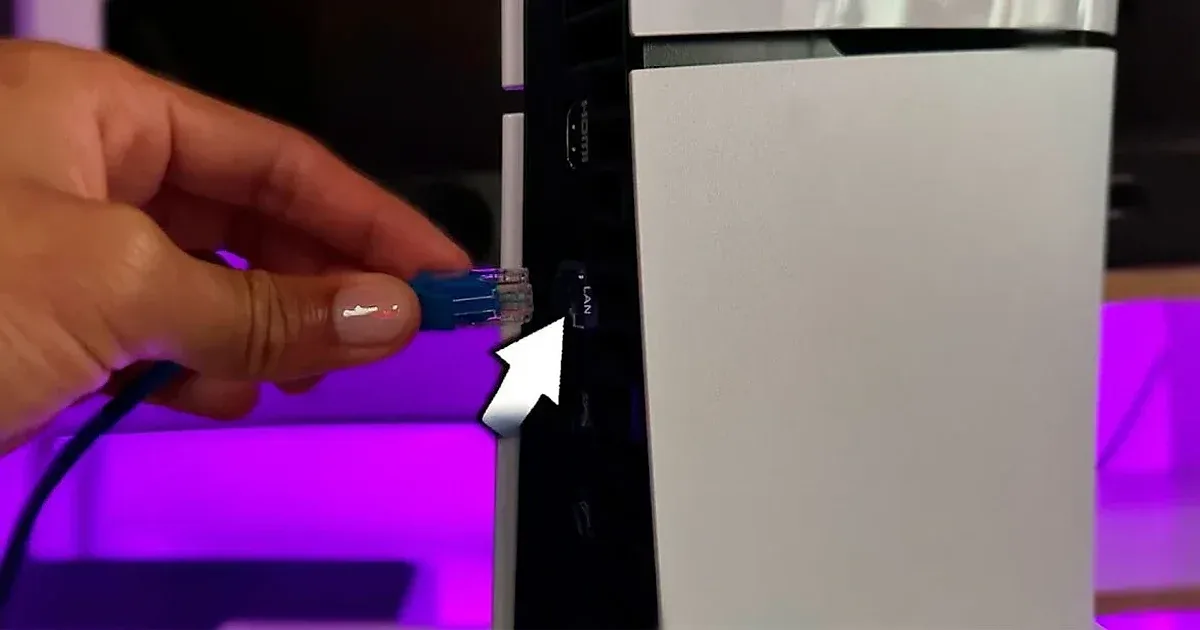 Cable de red LAN siendo conectado a la PS5 para mejorar conexión.