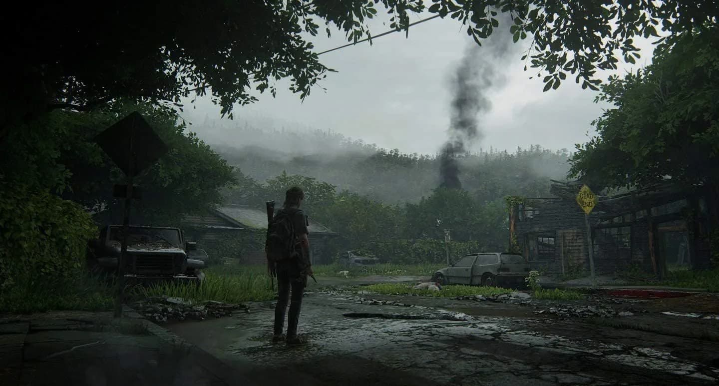 Ellie en pueblo post-apocalíptico abandonado con humo negro en The Last of Us Part II, señal "Dead End" visible.