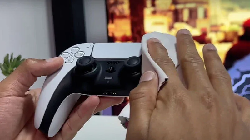Limpieza correcta del mando DualSense de PS5 con un paño suave sobre la superficie del controlador.