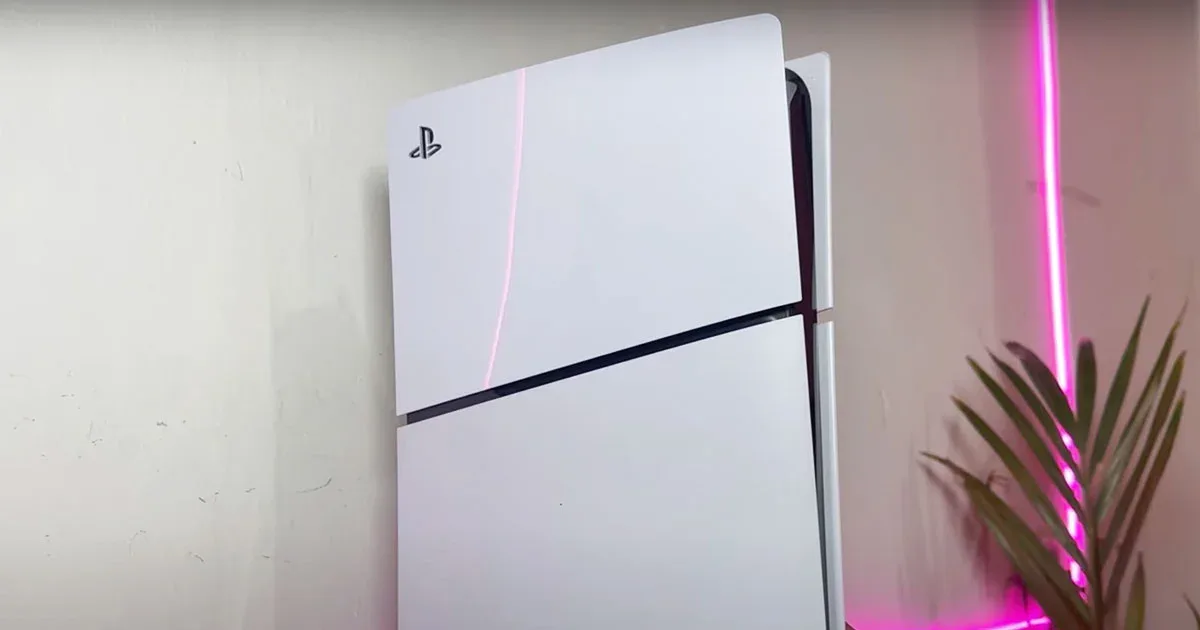 PS5 Slim en posición vertical con luz rosa de fondo, modelo compacto de la consola PlayStation 5 de Sony.