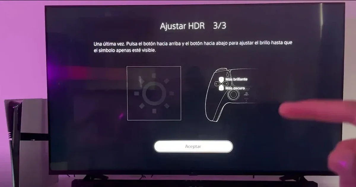 Pantalla PS5 mostrando el paso 3/3 del ajuste HDR con símbolo de brillo y mando DualSense en TV.